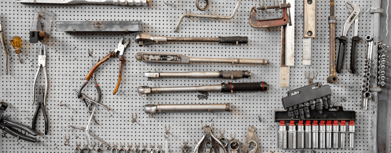Efficiently organised tools on a pegboard using hooks and accessories for workshop or home storage.