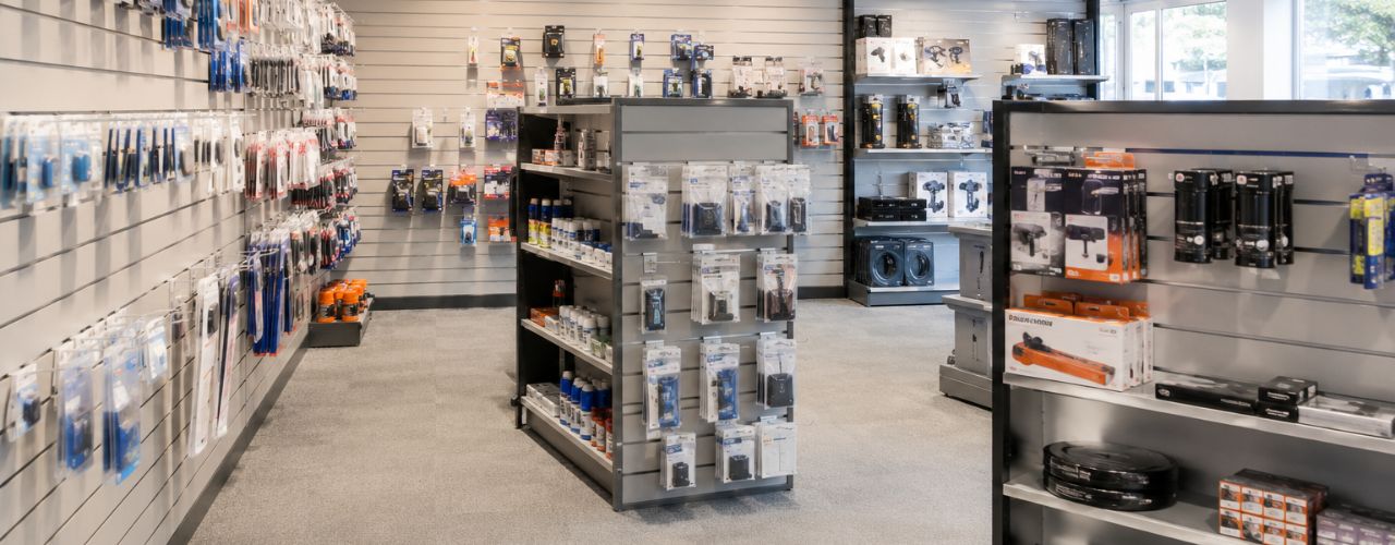 Well-organised retail store featuring slatwall panels, display hooks, shelving, and neatly presented merchandise